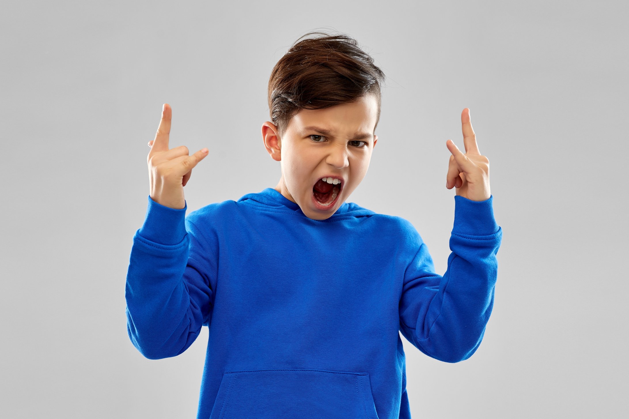 Angry Boy in Blue Hoodie Showing Rock Gesture